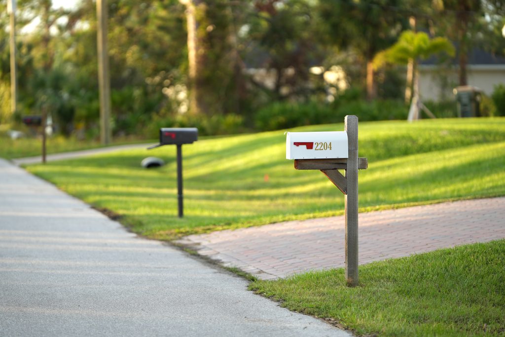 row of uniform residential mailboxes installed to standard height in an HOA community